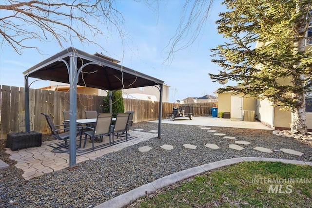 view of patio / terrace featuring a gazebo, outdoor dining area, and a fenced backyard