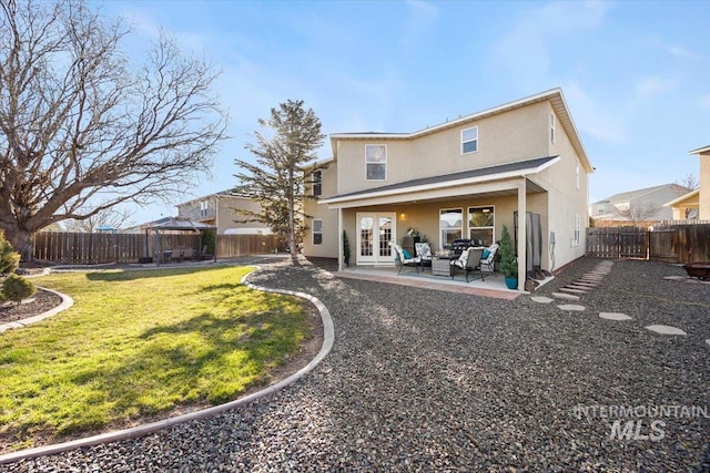 rear view of house with a fenced backyard, french doors, a gazebo, and a patio