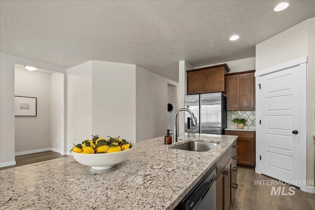 321 N Bay Haven Ave, Kuna, ID 83634 - kitchen with appliances with stainless steel finishes, a sink, dark wood-style flooring, tasteful backsplash, and light stone countertops