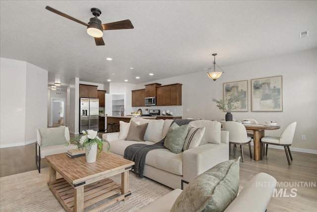 321 N Bay Haven Ave, Kuna, ID 83634 - living area with light wood-style flooring, ceiling fan, baseboards, and recessed lighting