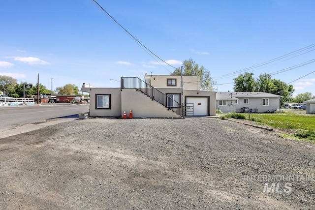 111 Main, Hagerman, ID 83332 - view of property with stairs, stucco siding, and driveway