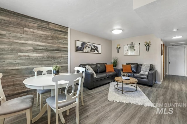 111 Main, Hagerman, ID 83332 - living room featuring wood finished floors, wood walls, an accent wall, and baseboards