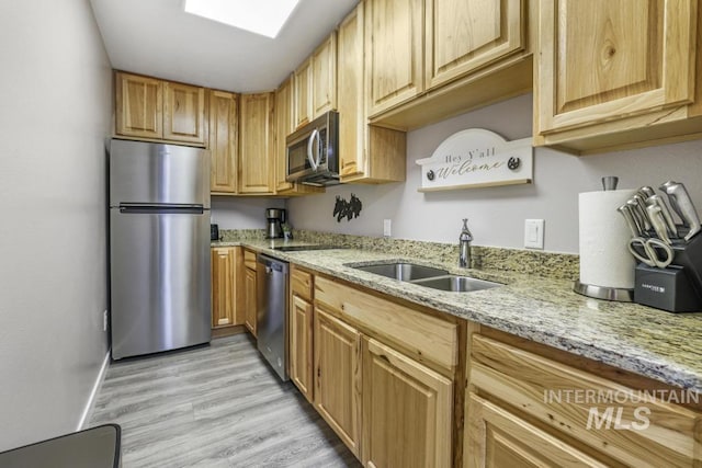 111 Main, Hagerman, ID 83332 - kitchen featuring stainless steel appliances, a sink, light wood-style flooring, and light stone countertops