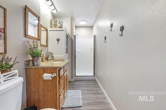 111 Main, Hagerman, ID 83332 - full bath featuring a shower stall, wood finished floors, vanity, baseboards, and toilet