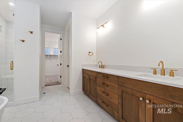 full bath with tile patterned floors, a sink, a stall shower, and double vanity