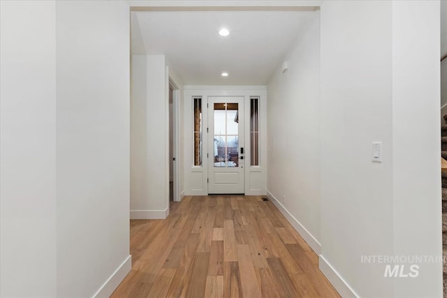 hallway featuring baseboards, light wood-style flooring, and recessed lighting