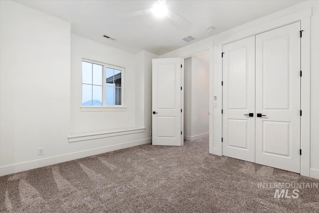 unfurnished bedroom with carpet flooring, baseboards, a closet, and visible vents