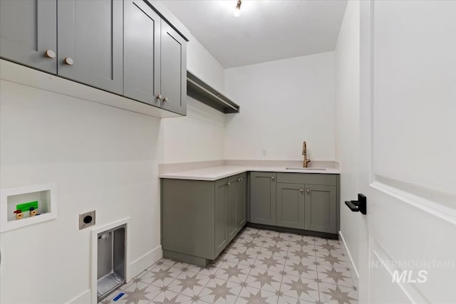 clothes washing area featuring a sink, light floors, hookup for an electric dryer, cabinet space, and hookup for a washing machine