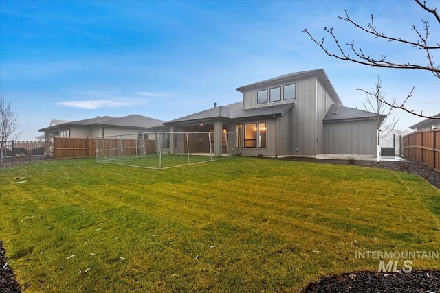 back of property featuring a fenced backyard, a lawn, a patio, and board and batten siding