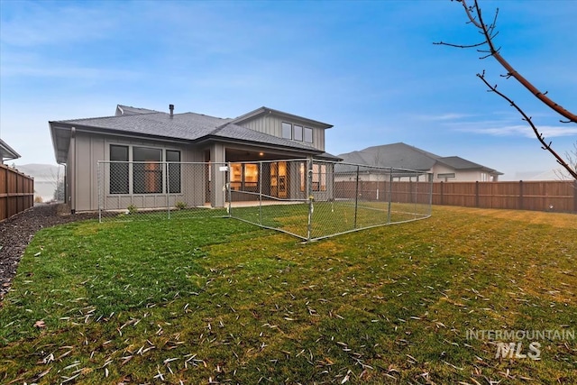 back of property featuring a fenced backyard, board and batten siding, a yard, and a patio area