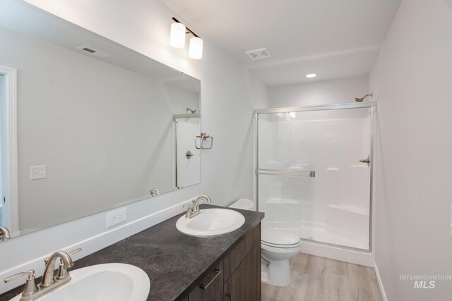 bathroom featuring walk in shower, toilet, vanity, and hardwood / wood-style flooring