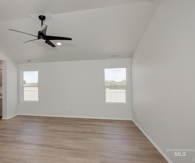 unfurnished room featuring lofted ceiling, a healthy amount of sunlight, light wood-type flooring, and ceiling fan