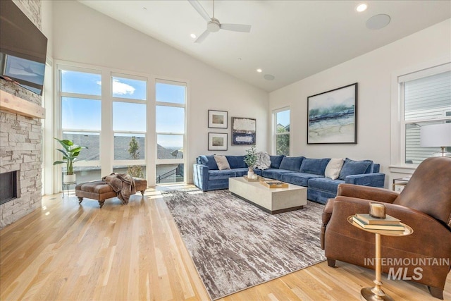 2391 S Trapper Pl, Boise, ID 83716 - living room with ceiling fan, high vaulted ceiling, a stone fireplace, recessed lighting, and wood finished floors