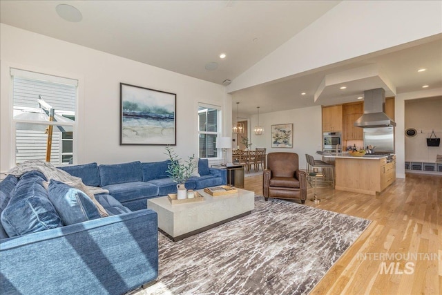 2391 S Trapper Pl, Boise, ID 83716 - living room with light wood-type flooring, recessed lighting, lofted ceiling, and a notable chandelier