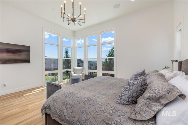 2391 S Trapper Pl, Boise, ID 83716 - bedroom with baseboards, a notable chandelier, and wood finished floors
