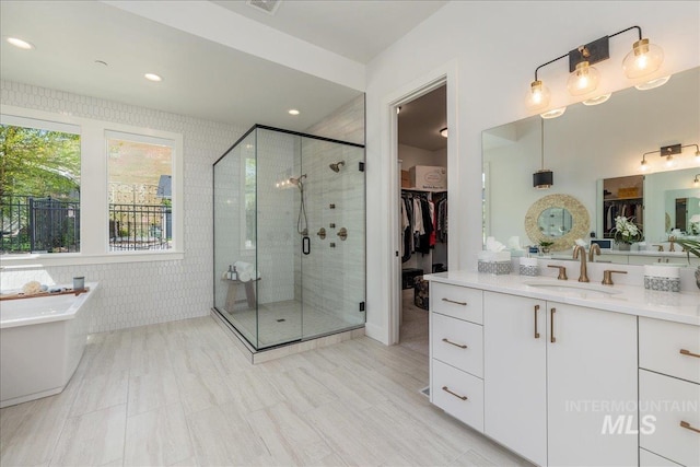 2391 S Trapper Pl, Boise, ID 83716 - full bathroom with vanity, a walk in closet, recessed lighting, a freestanding bath, and a shower stall