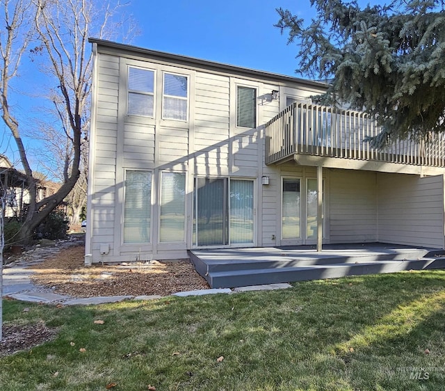 back of property with a yard and a deck