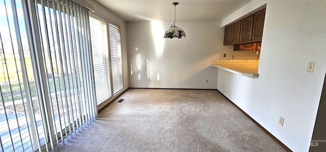 unfurnished dining area with light colored carpet