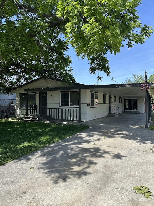 215 S Ivy St, Nampa, ID 83686 - ranch-style home featuring an attached carport, concrete driveway, and a front yard