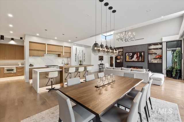 1865 E Lone Shore Ln, Eagle, ID 83616 - dining area with light wood-type flooring, recessed lighting, a notable chandelier, and a fireplace