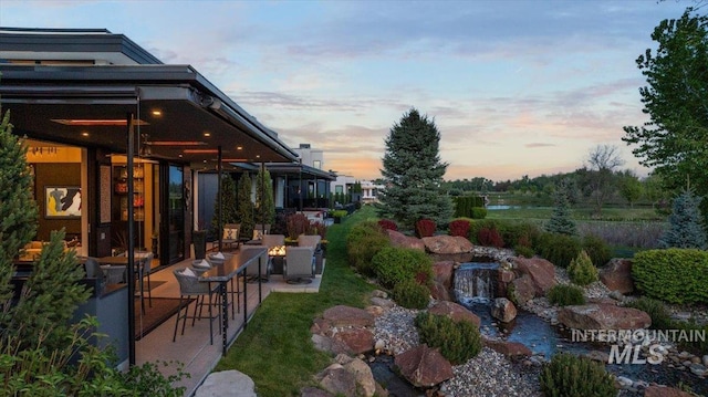1865 E Lone Shore Ln, Eagle, ID 83616 - yard at dusk with a small pond and a patio