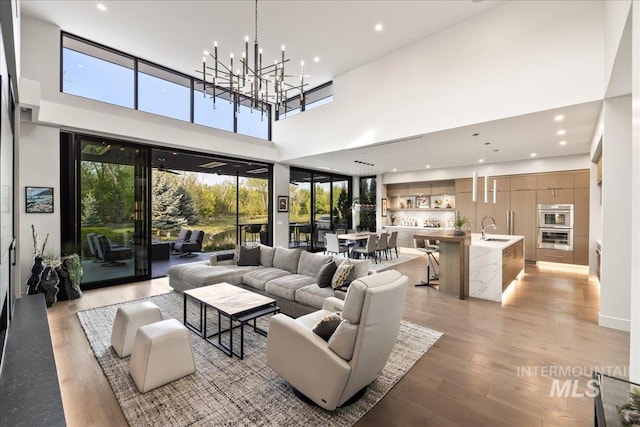 1865 E Lone Shore Ln, Eagle, ID 83616 - living area with light wood-style floors, a high ceiling, recessed lighting, and a chandelier