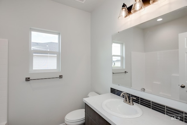bathroom with vanity, toilet, and baseboards