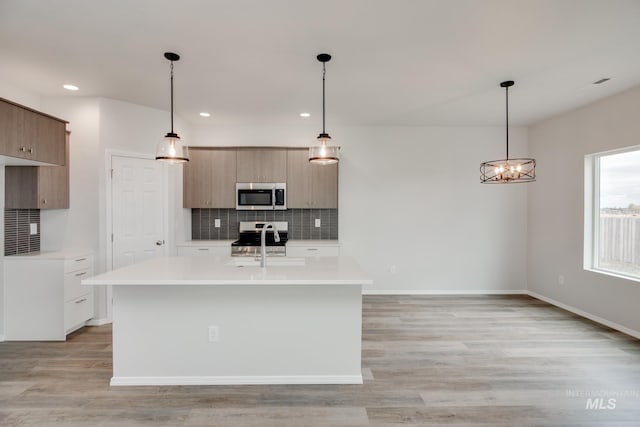 kitchen with modern cabinets, light countertops, stainless steel appliances, and decorative backsplash