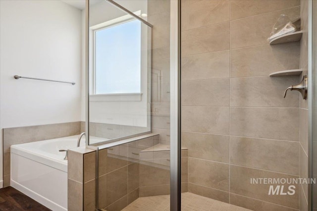 full bathroom with a bath, a stall shower, and wood finished floors
