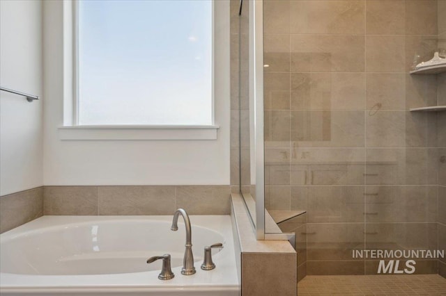 full bathroom featuring a bath and tiled shower