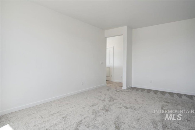 unfurnished room with carpet floors and baseboards