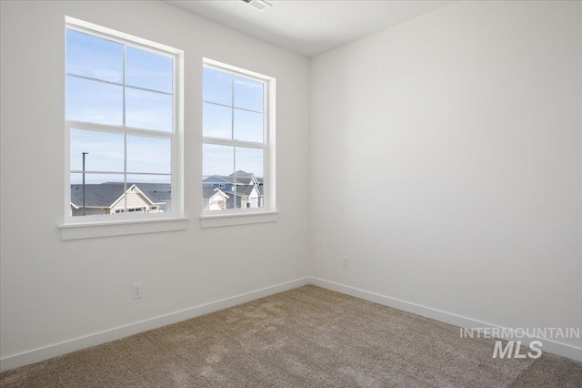 carpeted spare room with baseboards