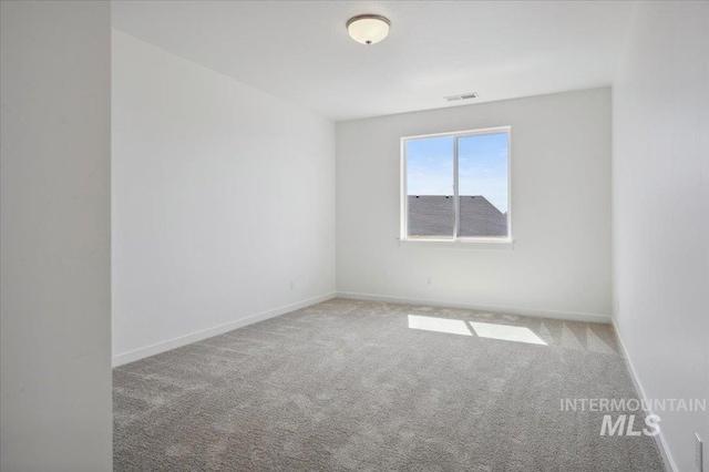 unfurnished room featuring baseboards, visible vents, and carpet