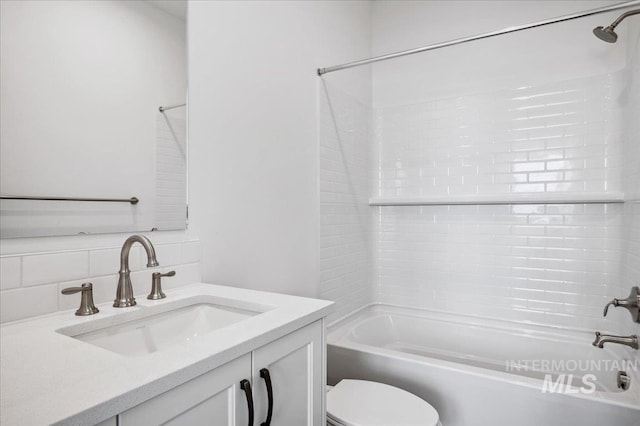 bathroom featuring backsplash, tub / shower combination, toilet, and vanity