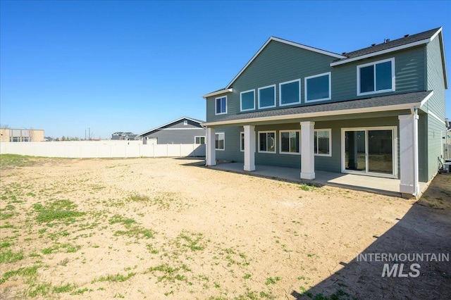 rear view of property featuring fence and a patio area