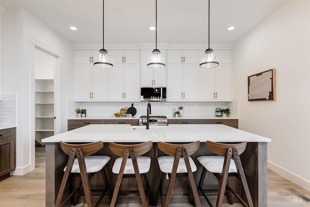 12507 S Lenora Pl, Nampa, ID 83686 - kitchen with light countertops, decorative backsplash, appliances with stainless steel finishes, and a kitchen breakfast bar