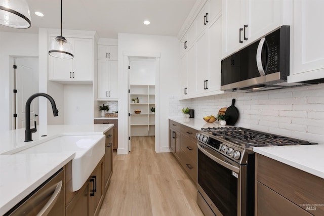 12507 S Lenora Pl, Nampa, ID 83686 - kitchen with light countertops, light wood-style flooring, stainless steel appliances, a sink, and white cabinets