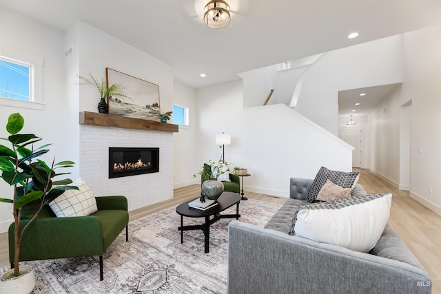 12507 S Lenora Pl, Nampa, ID 83686 - living room with light wood-style flooring, a brick fireplace, baseboards, stairs, and recessed lighting