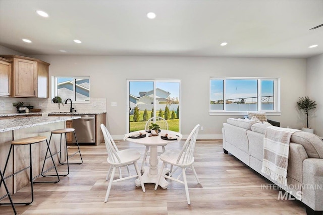 dining room featuring baseboards, recessed lighting, and light wood-style flooring