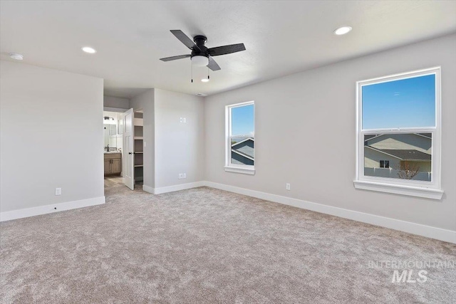 interior space with connected bathroom, baseboards, recessed lighting, and carpet floors