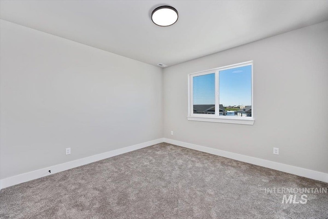 carpeted spare room with baseboards