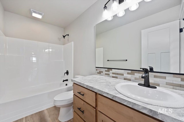 full bath featuring washtub / shower combination, vanity, toilet, visible vents, and wood finished floors