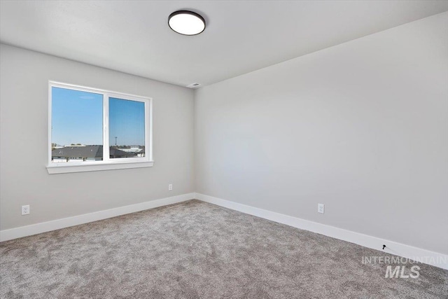 carpeted spare room with baseboards