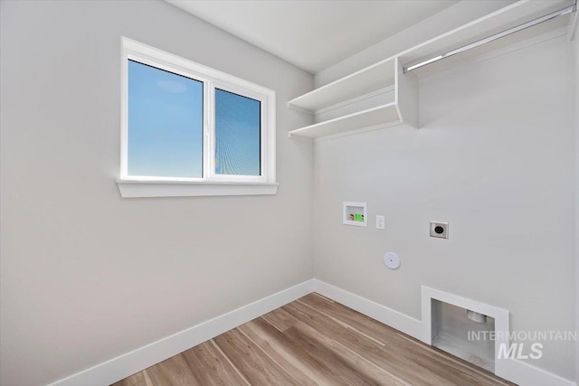 laundry area with laundry area, electric dryer hookup, hookup for a washing machine, light wood-style flooring, and baseboards