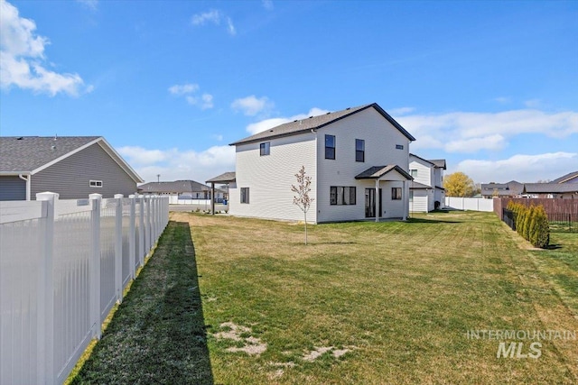 back of property featuring a yard and a fenced backyard