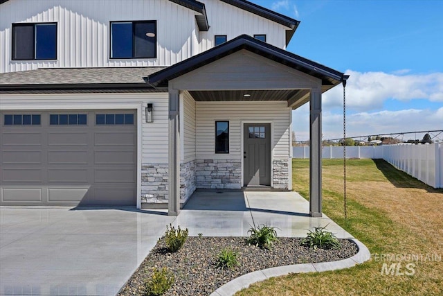 view of front of property featuring board and batten siding, a front yard, an attached garage, fence, and a porch