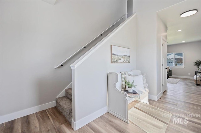 stairs featuring wood finished floors, recessed lighting, and baseboards