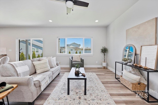 living room featuring ceiling fan, light wood-type flooring, recessed lighting, and baseboards
