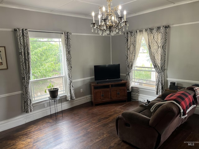 living room featuring hardwood / wood-style floors, a chandelier, crown molding, and baseboards