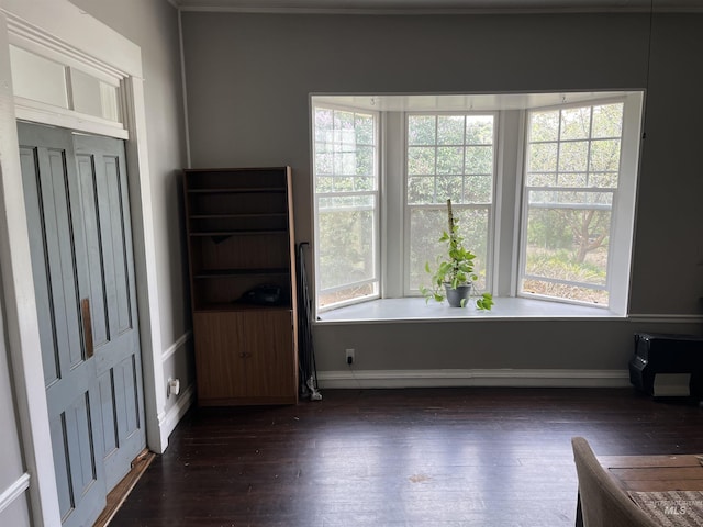 empty room with baseboards and dark wood finished floors
